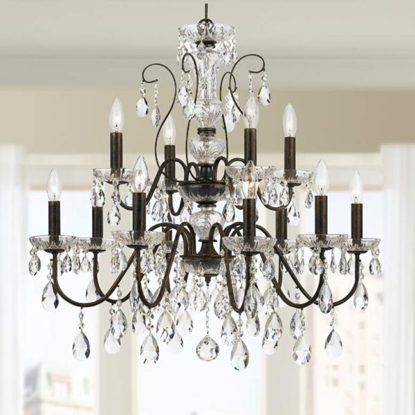 Image of a Butler 12 Light English Bronze Crystal Chandelier. The chandelier is made of metal and crystals and has a cascading design. It is hanging from the ceiling of a room.