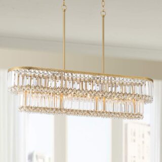 A chandelier made of gold-plated metal and crystal hanging from the ceiling of a dining room.