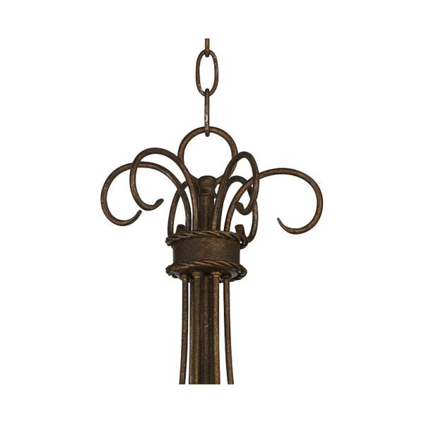 A wrought iron chandelier hanging from a chain. The chandelier has six candle sleeves that are filled with candles. The candles are burning, creating a warm and inviting glow.