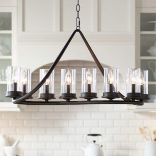 A bronze chandelier with 10 lights hangs over a kitchen counter. The chandelier has a linear design with clear glass cylinders.