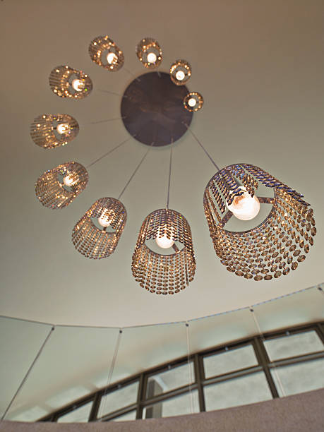 A bunch of lights hanging from a ceiling. The lights are made of metal and glass and have a chandelier-like design.