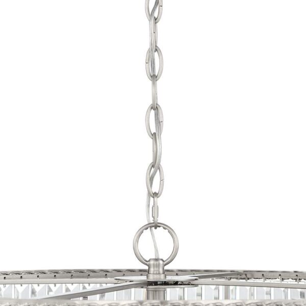 Close-up of a stainless steel chain hanging from a crystal chandelier. The chain is attached to the ceiling and is supporting the weight of the chandelier. The chandelier is made of clear crystals and has a round base.