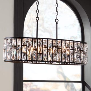 Black chandelier with clear crystals hanging from a chain in a modern dining room.