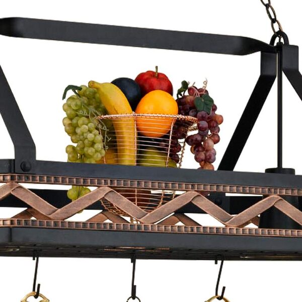 A basket of fruit sitting on top of a pot rack. The fruit includes apples, oranges, bananas, and grapes.