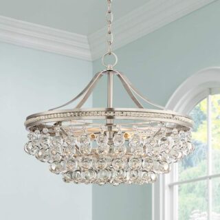 A luxurious chandelier made of clear crystals hangs from the ceiling of a large room.